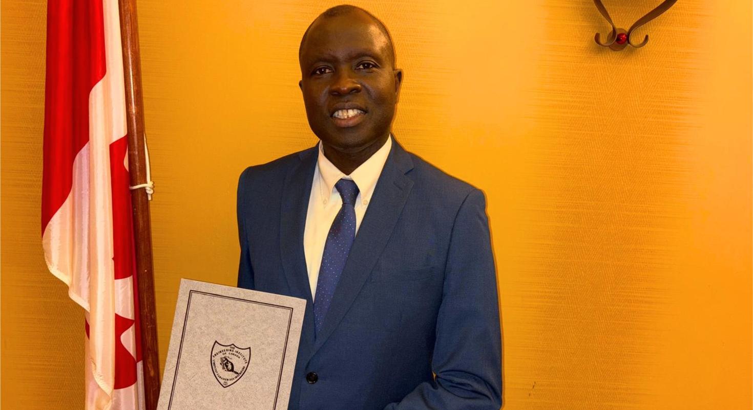 Mamadou fall holding an award