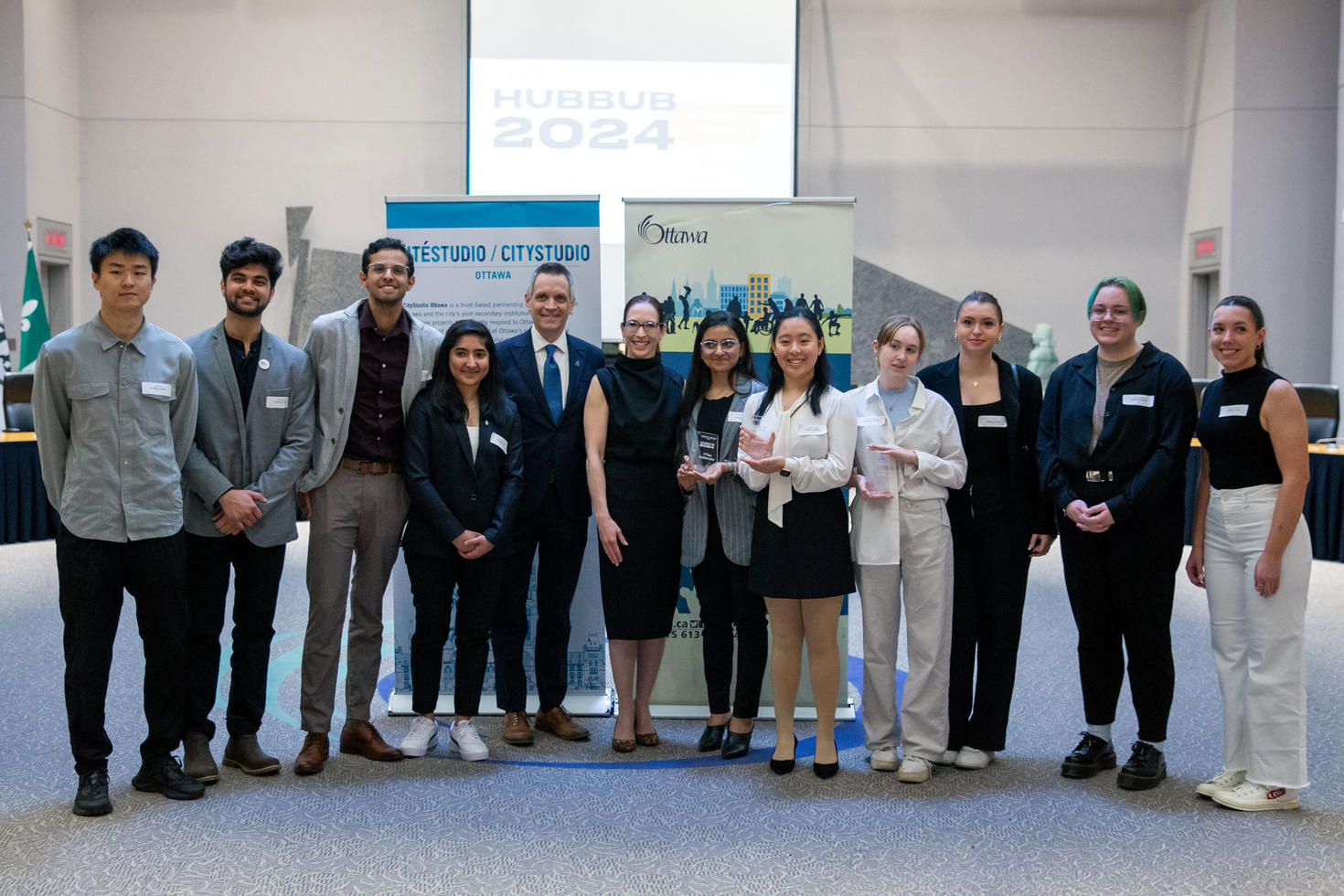 A group of students stands in a row, with the Ottawa mayor in the centre