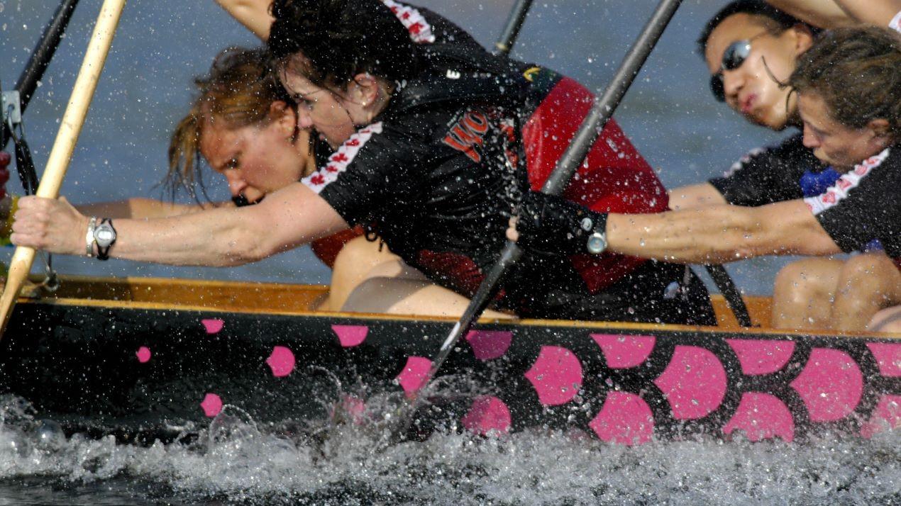 Une équipe de bateaux-dragons ramant à pleine vitesse.