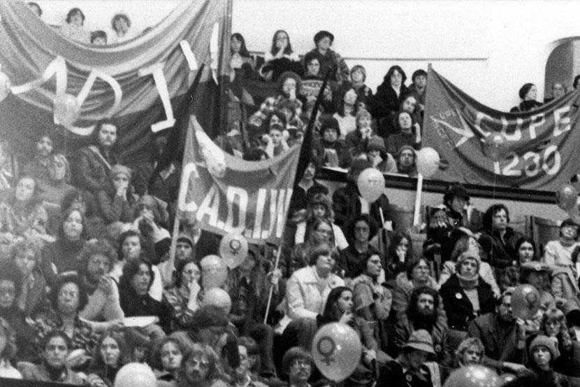 Nancy Adamson, photographe. Membres de l'ACSF et bannières dans l'auditoire lors du rassemblement de la Journée internationale de la femme, Convocation Hall, Université de Toronto (11 mars 1978), Archives et collections spéciales, Université d'Ottawa, 10-001-S3-I209