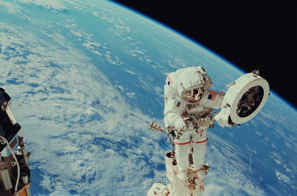 Astronaute en sortie dans l'espace avec la Terre en arrière-plan