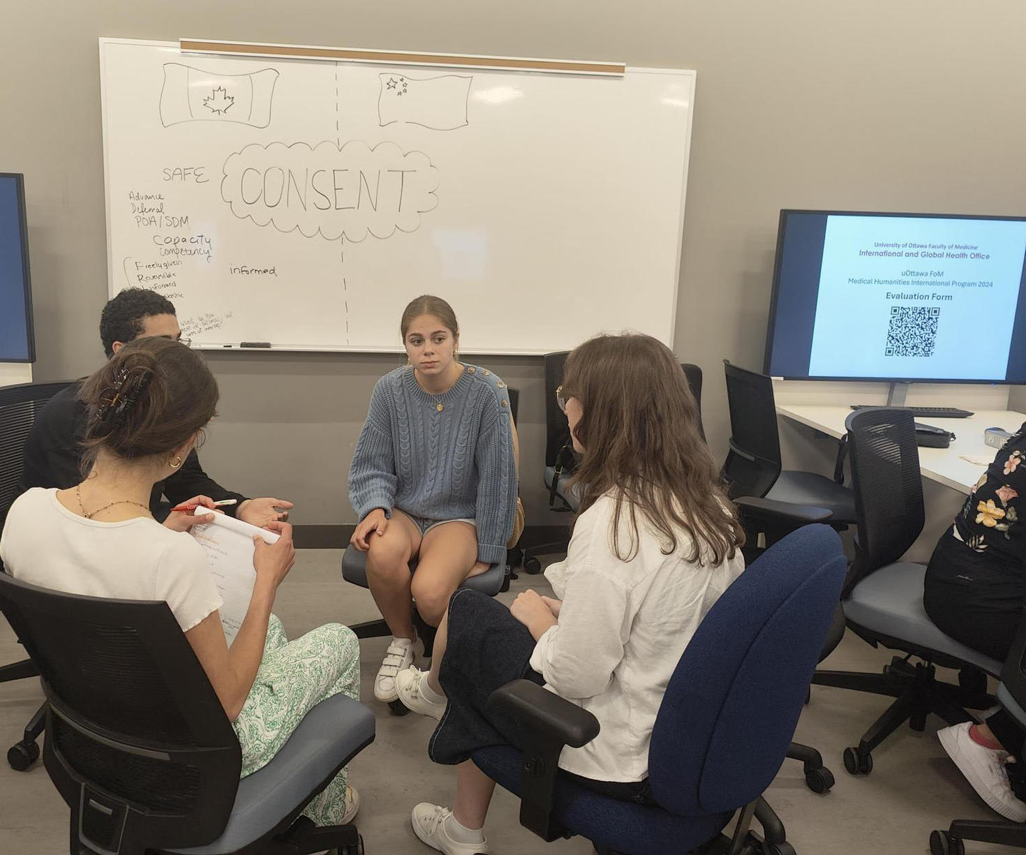 Four students sitting in a circle talking together