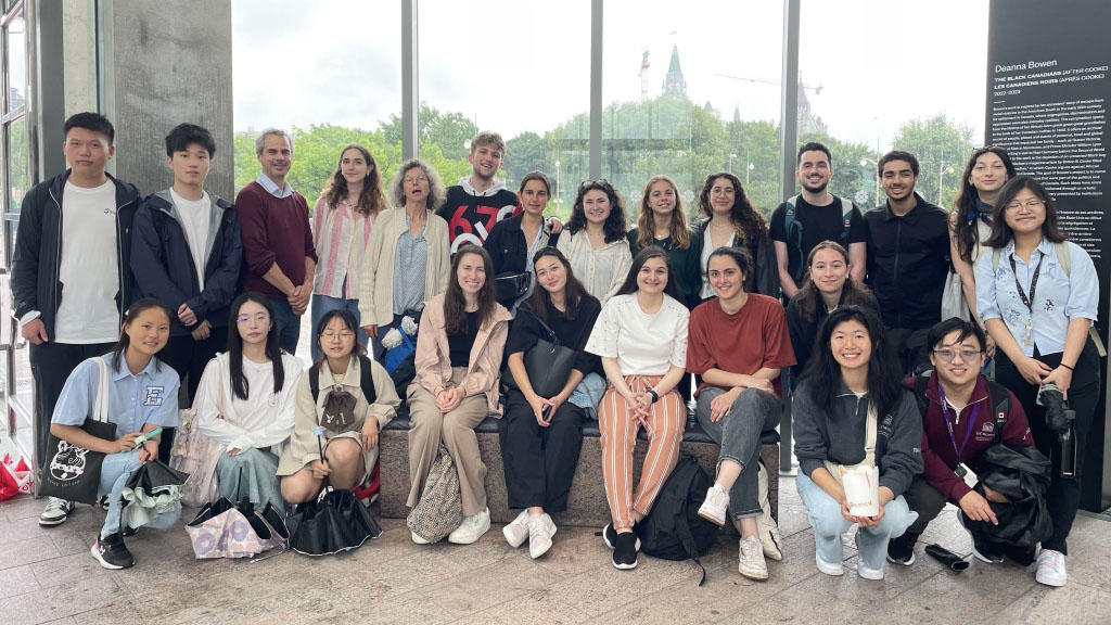 Vingt-quatre étudiants posent pour la caméra devant une fenêtre.