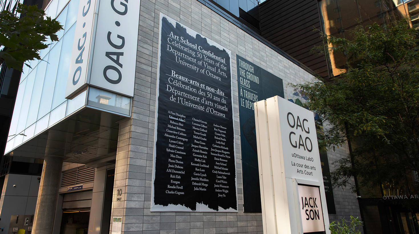 Vue de l’extérieur de la Galerie d’art d’Ottawa avec l’affiche géante qui présente les noms des 50 artistes dont les œuvres composent l’exposition Beaux-arts et non-dits, organisée par Penny Cousineau-Levine, professeure émérite du Département d’arts visuels de l’Université d’Ottawa. Ces artistes de renom ont enseigné et étudié au Département.