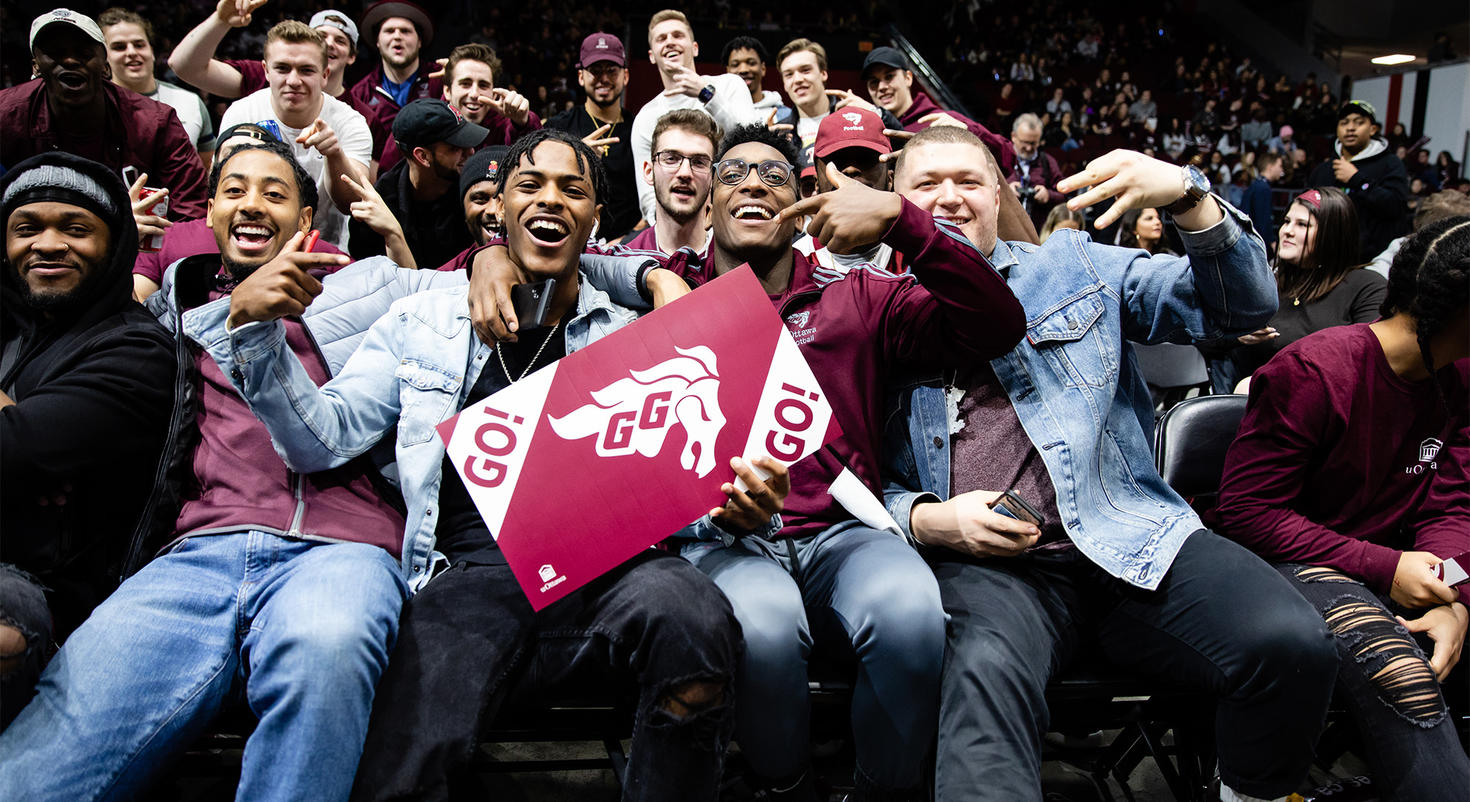 Students cheering as they watch a Gee-Gees game.