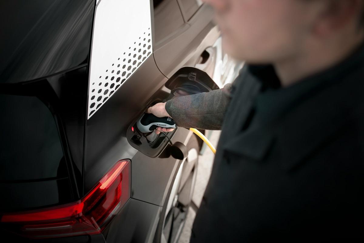 Homme chargeant un véhicule électrique