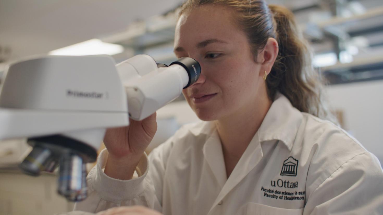 Student looking through a microscope