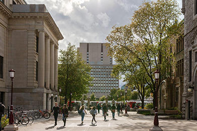 View of campus in the early Fall with people walking between Tabaret Hall and and Hagen.