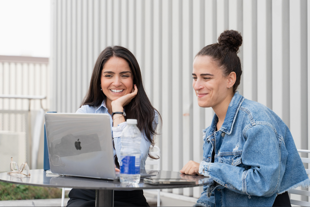 Two students in front of a laptop