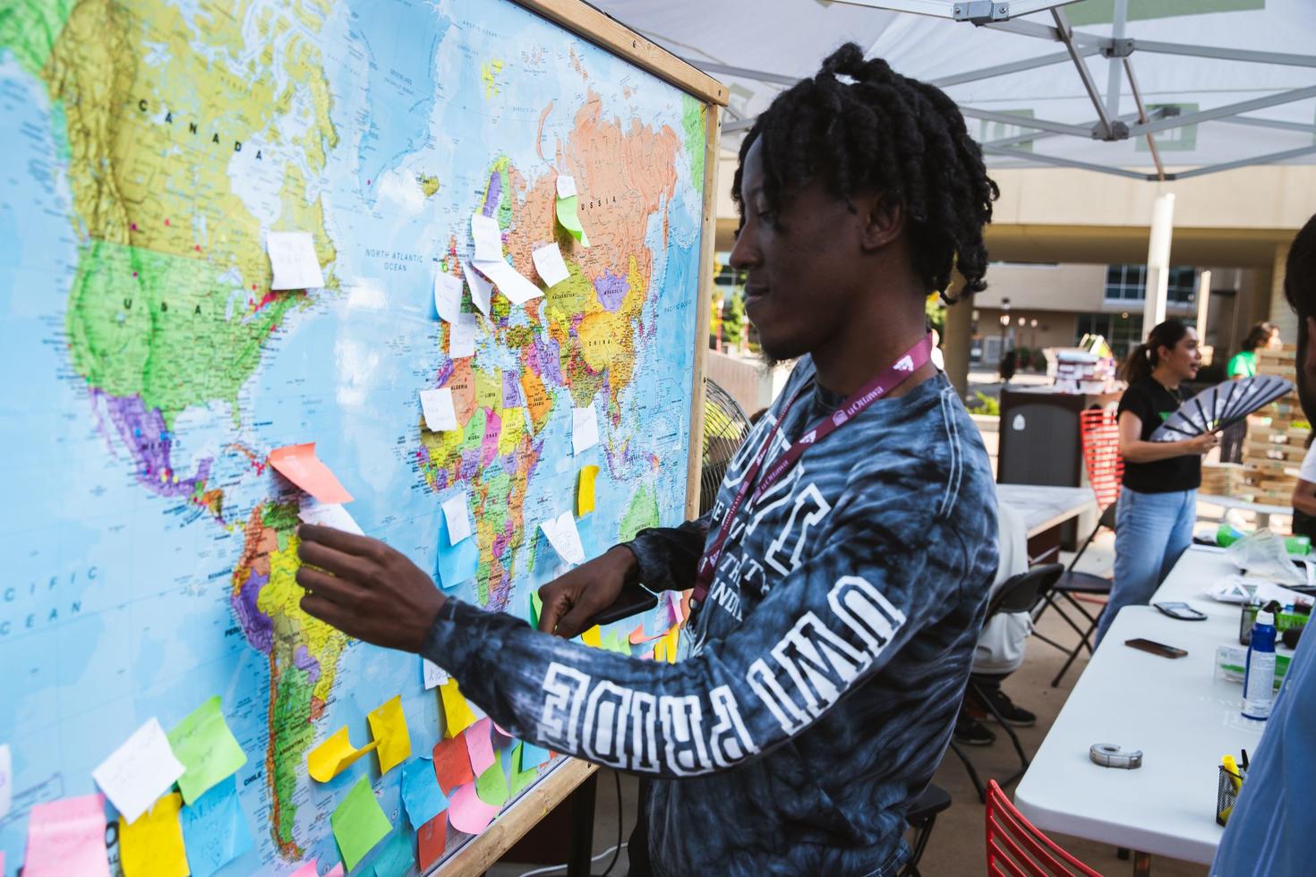 An international student in front of a map of the world.