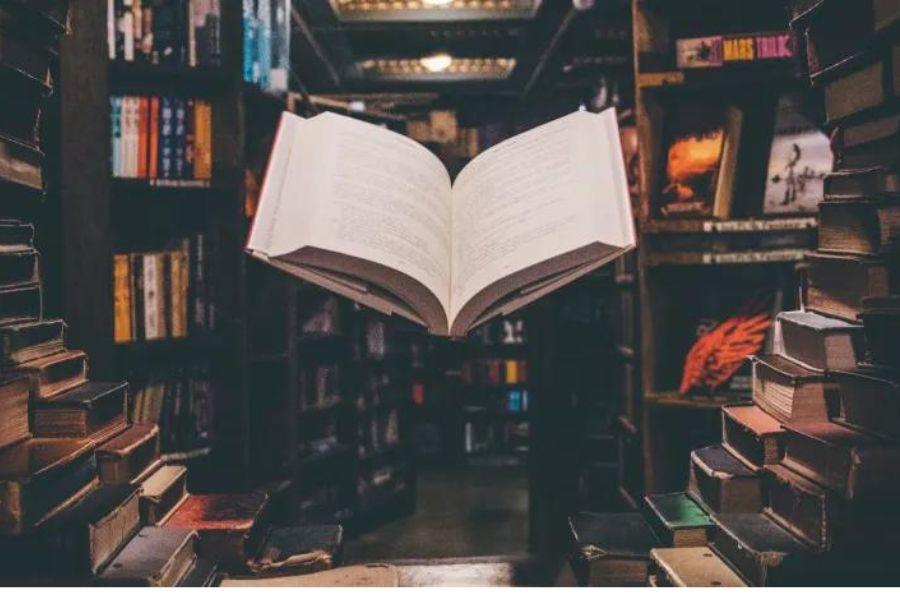 Un livre ouvert entouré d'une bibliothèque.