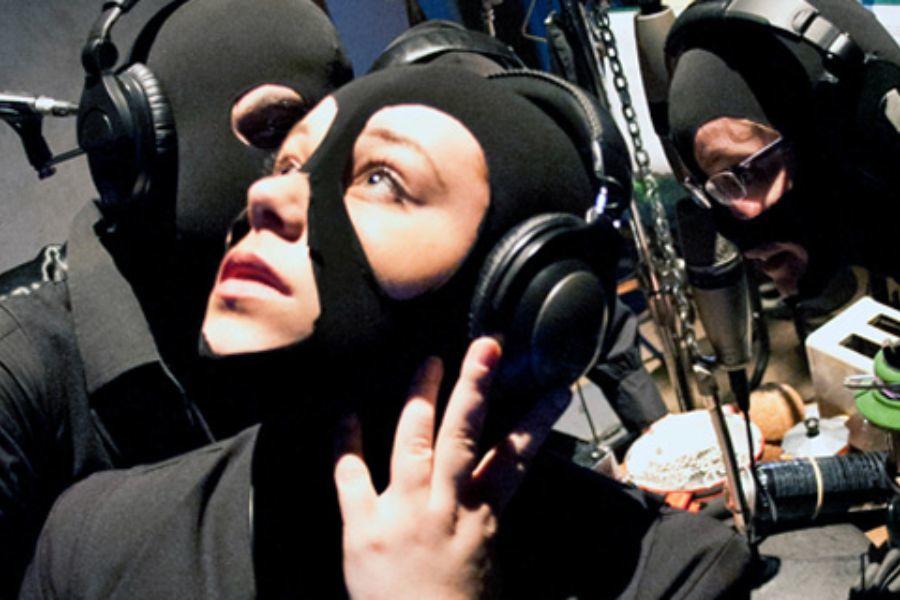 Une femme avec un masque noir et des écouteurs pour une production.