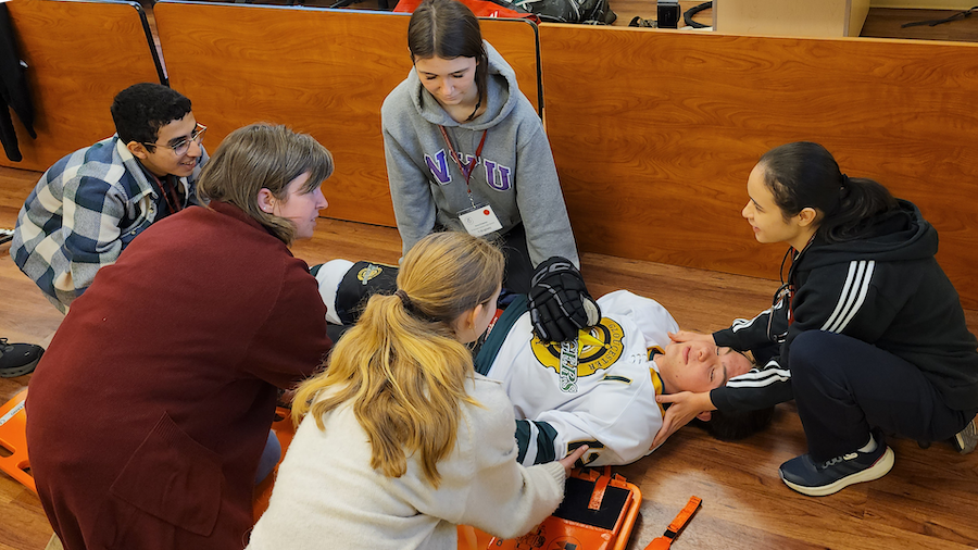 students providing emergency care to a volunteer patient