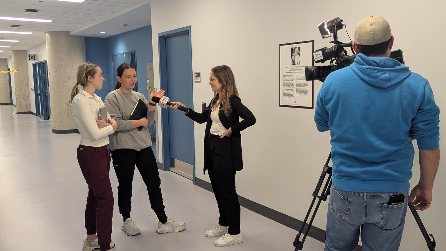 Deux étudiantes en soins infirmiers donnant une entrevue télévisée à une journaliste et filmées par un caméraman.