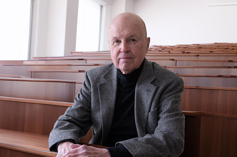 Professor Carl McMillan sitting in a classroom auditorium.