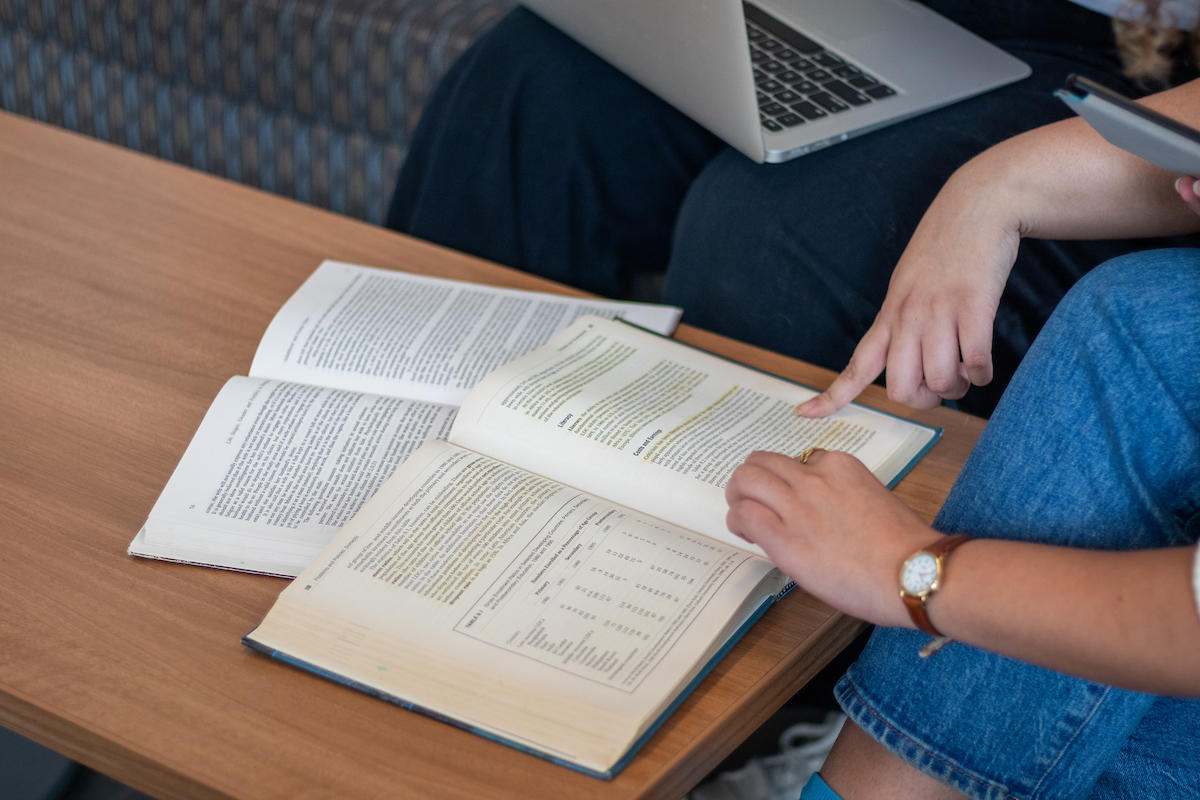 Des étudiantes qui étudient avec un laptop et un livre