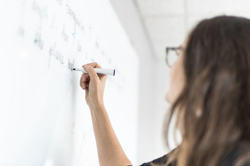 Personne écrivant sur un tableau blanc