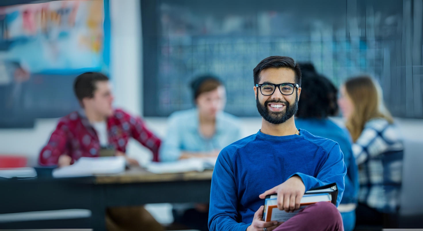 Une personne souriante dans une salle de classe.