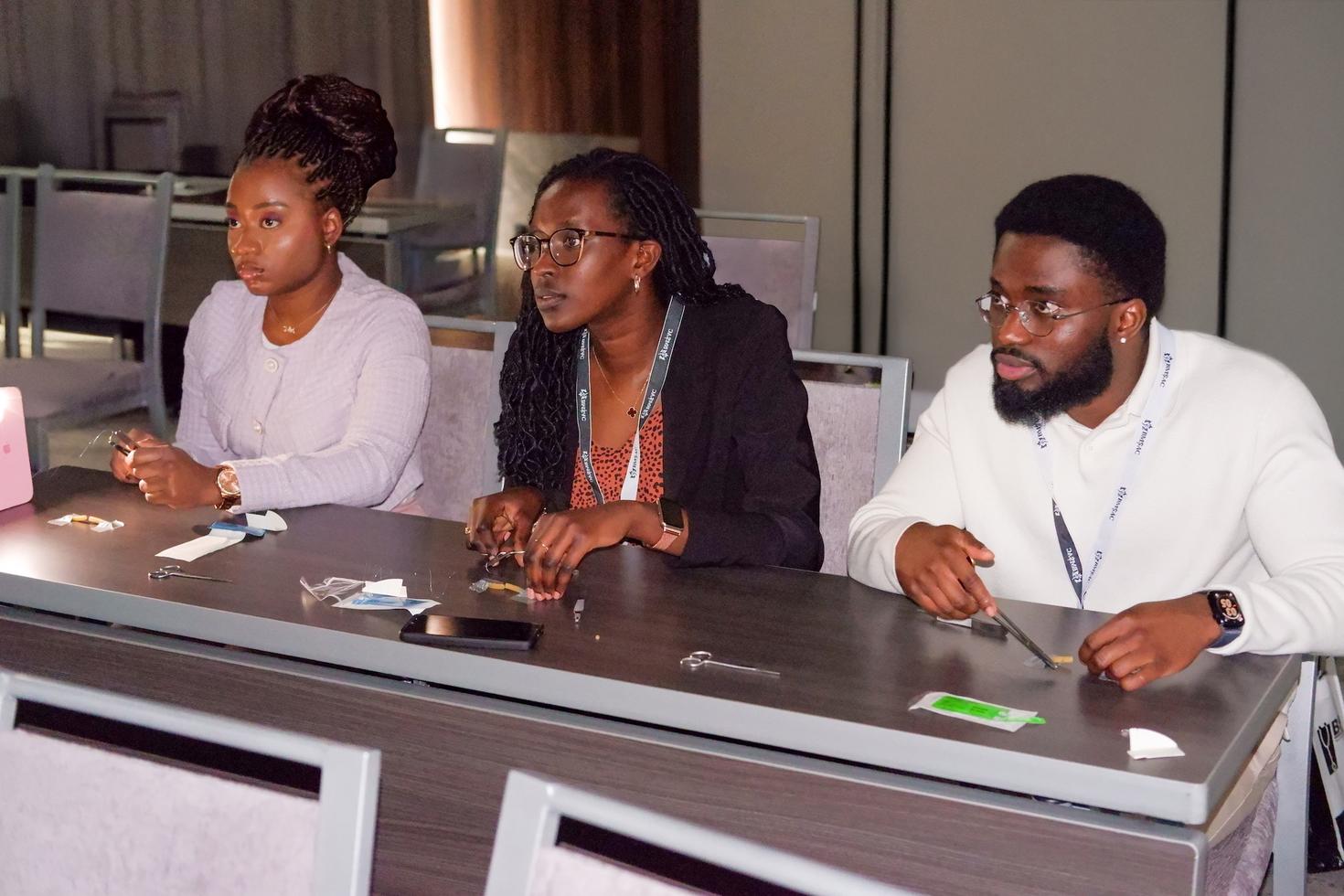 Trois étudiants en médecine apprenant une compétence médicale dans une salle de classe.