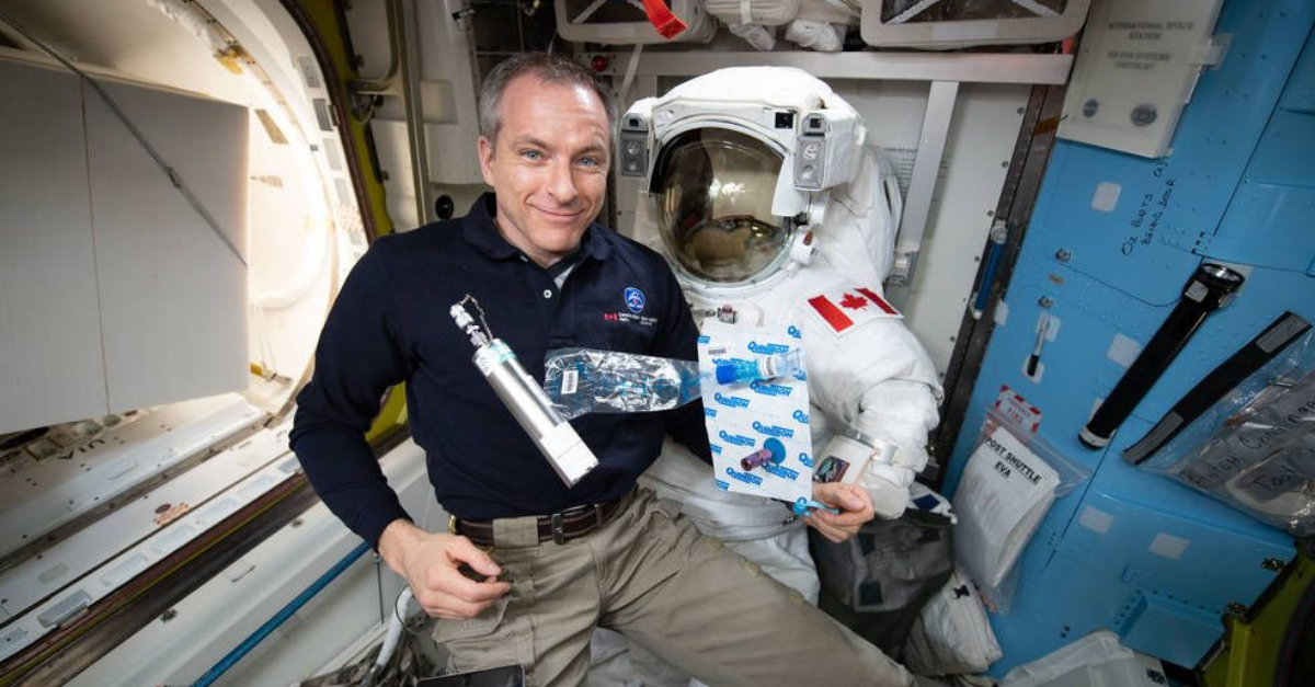 Canadian Space Agency (CSA) astronaut David Saint-Jacques, aboard the International Space Station, holds medical research equipment, including a syringe and sample collection kit. 
