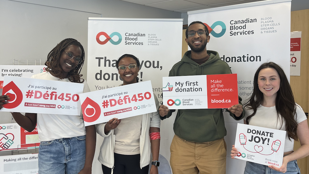 People standing with signs inviting others to give blood