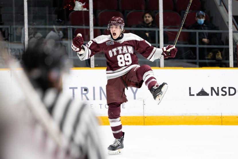 A Gee-Gees hockey player celebrates a goal with a fist pump.