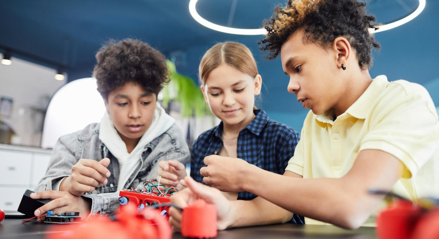Trois enfants travaillent avec des câbles.