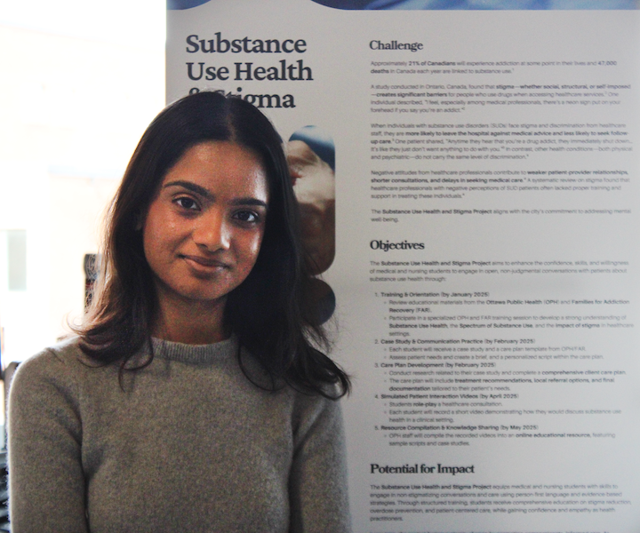 Le gagnant du meilleur projet de l’Université d’Ottawa se tient à côté de son affiche.