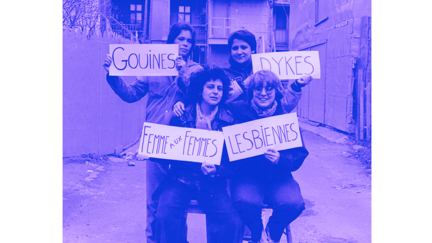 Quatre femmes portant des pancartes disant : Gouines, Dykes, Femme aux Femmes, Lesbiennes.