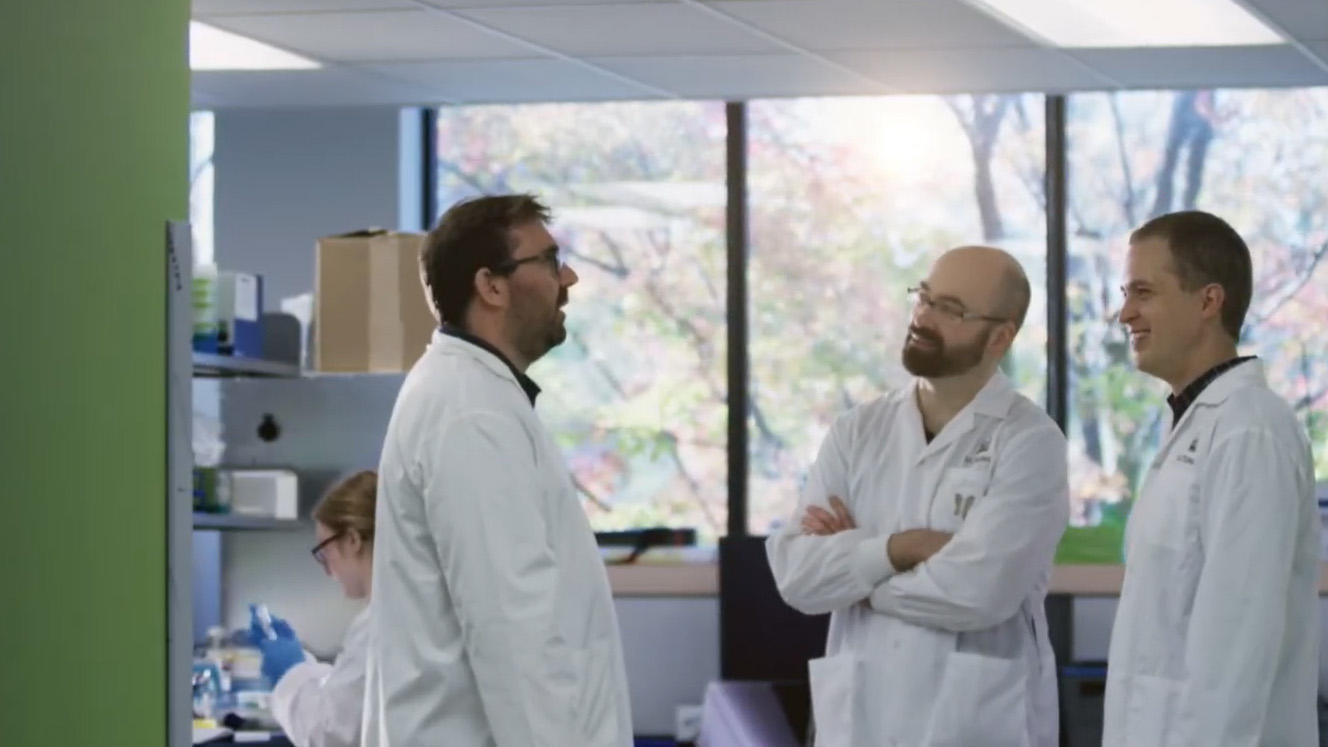Trois professeurs discutant dans un laboratoire