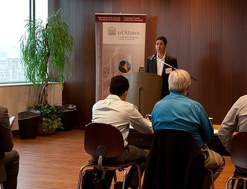 Individu installé à un podium s’adressant à un auditoire.