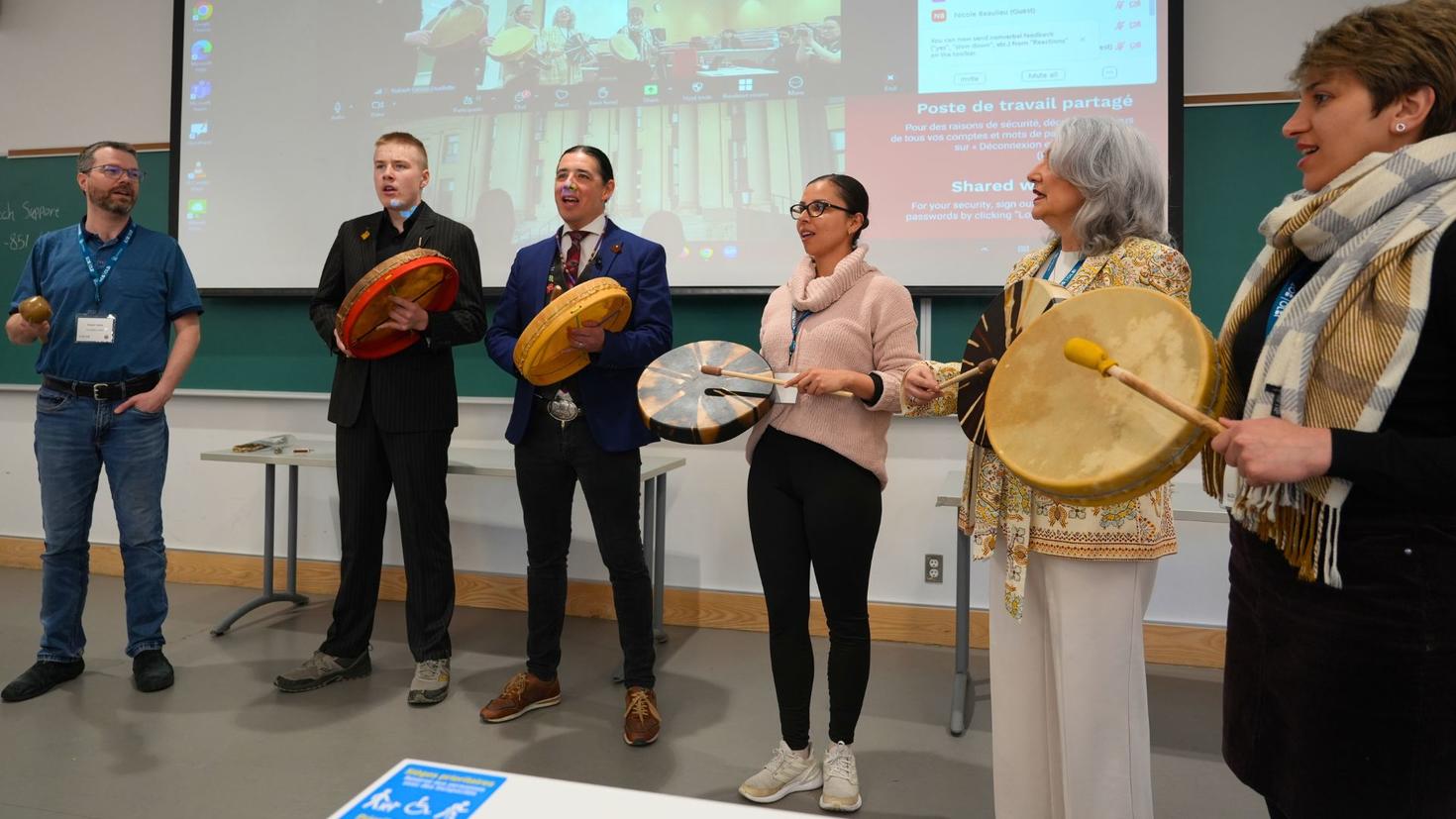A group of people holding Indigenous drums