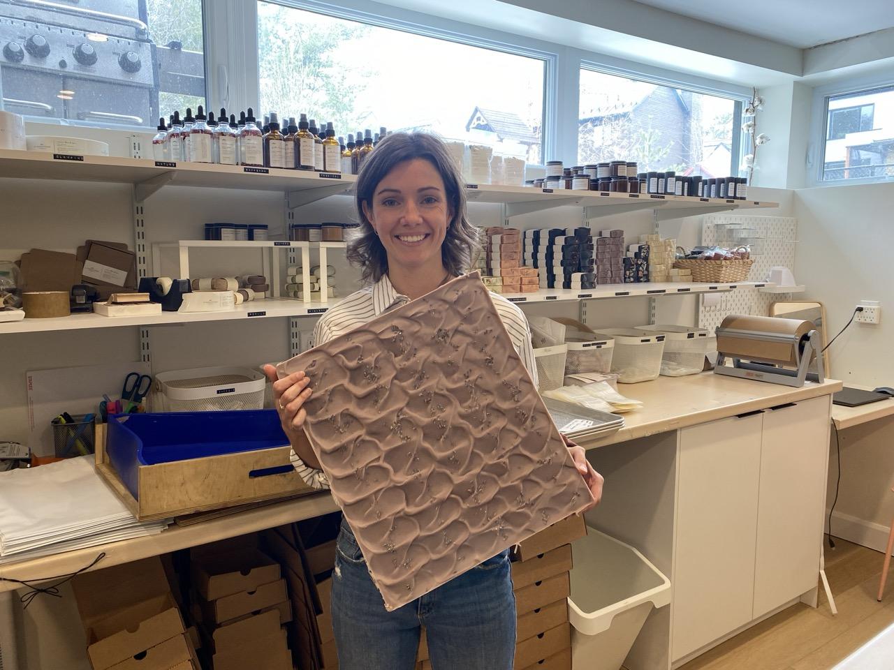 Owner of La Marcotterie, Elodie Marcotte, holds up a pre-cut block of her artisanal soap. 