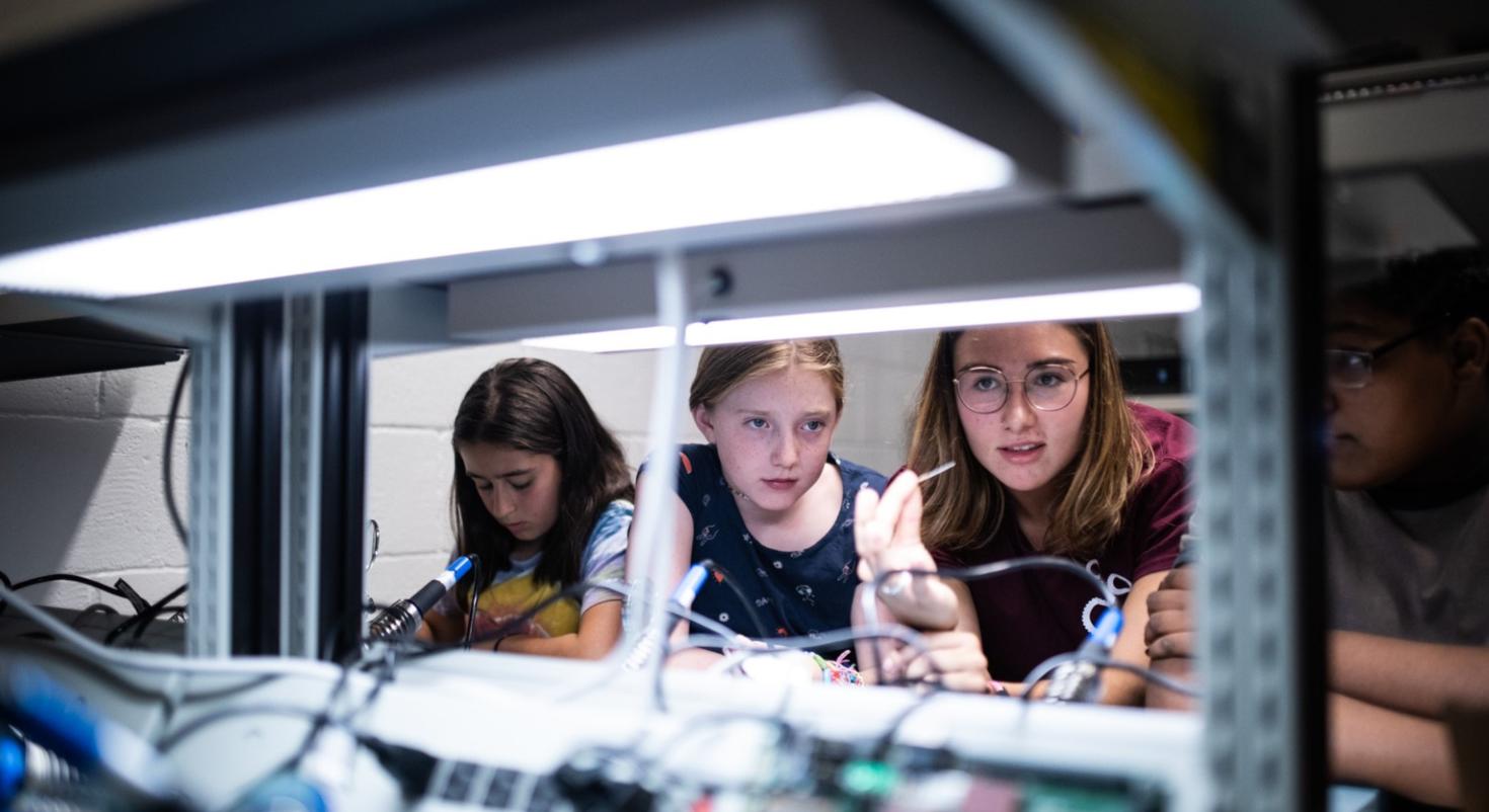 Three youth in an engineering lab.