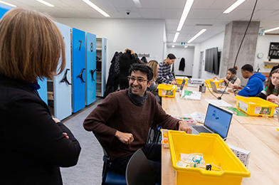 Un étudiant dans l'edstudio souriant devant un membre du corps professoral.