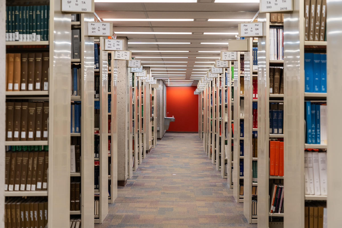 A library aisle with rows of bookshelves