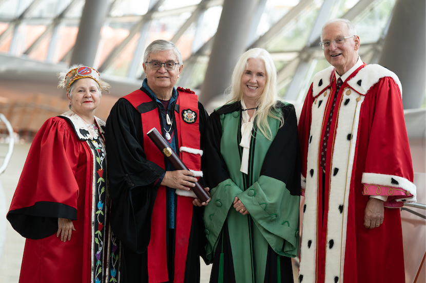 Quatre personnes debout ensemble, vêtues des habits officiels de dignitaires de l’Université d’Ottawa.