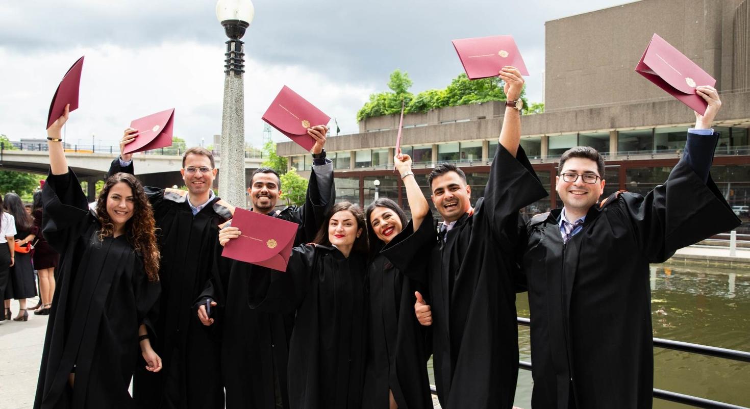 Des étudiants tenant leur diplôme.