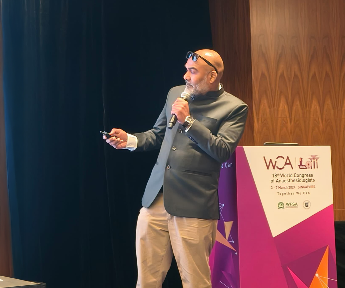 Dr. Wesley Rajaleelan presenting on a stage.