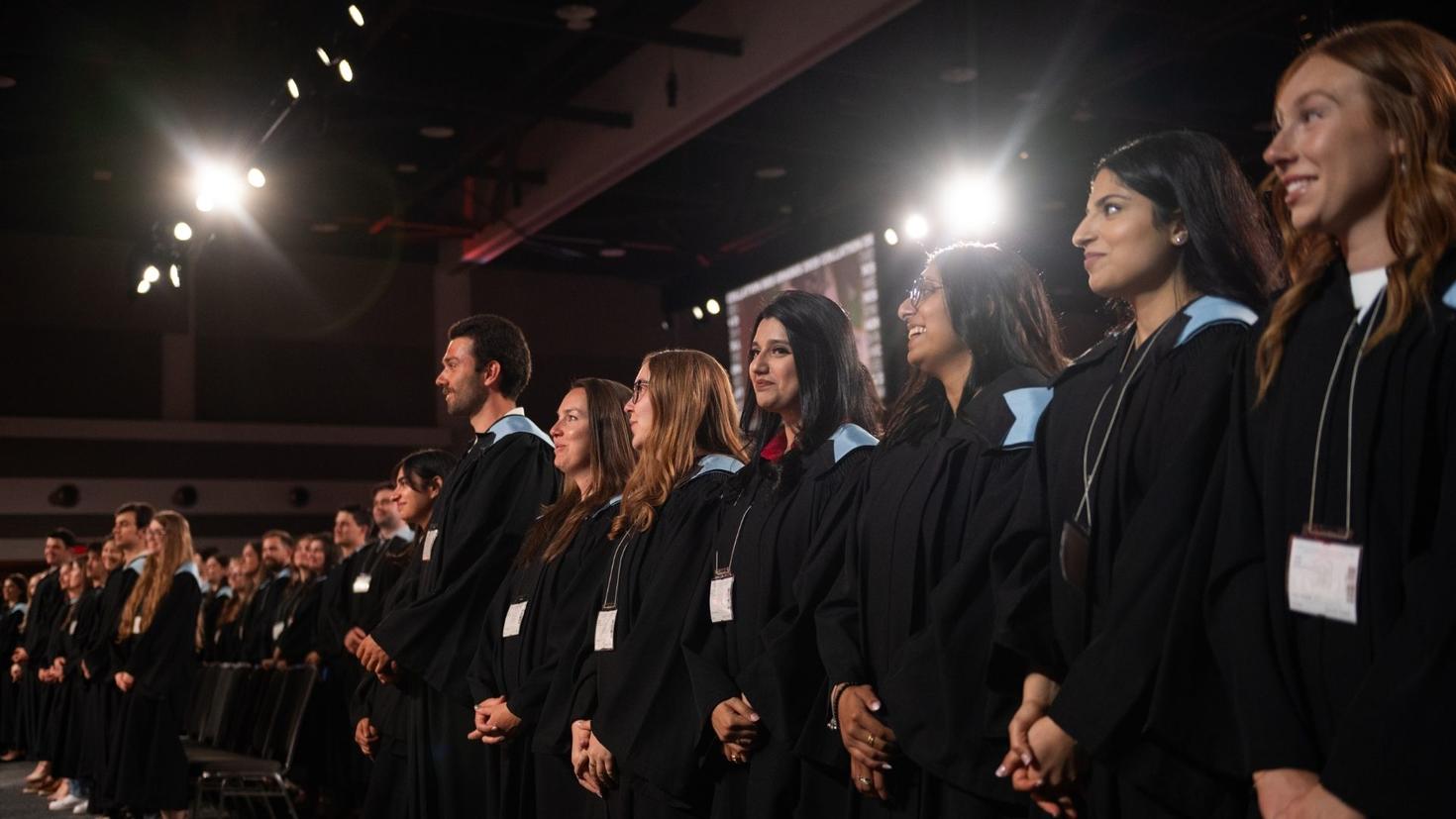 Graduates standing up during the ceremony