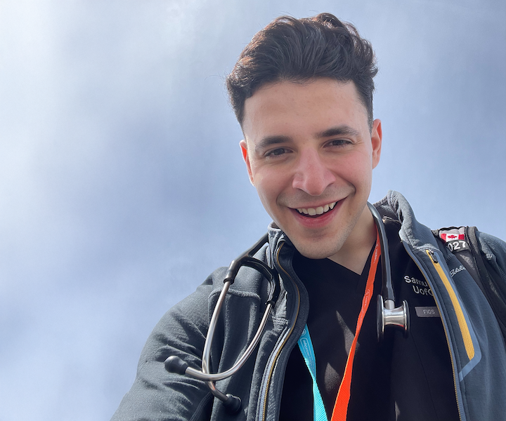 Une jeune personne debout à l’extérieur, un stéthoscope autour du cou.