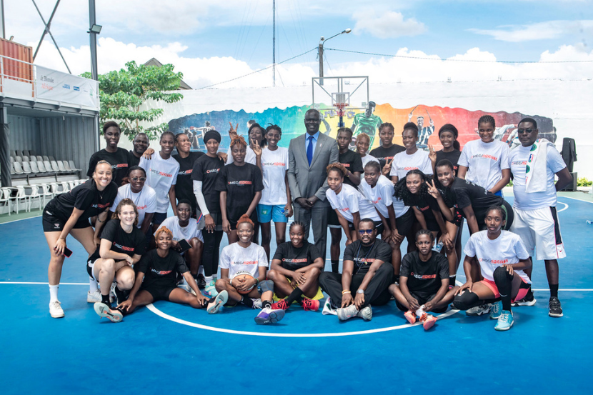 Kaly and a group of young women at an Omega Sports Holding basketball camp.