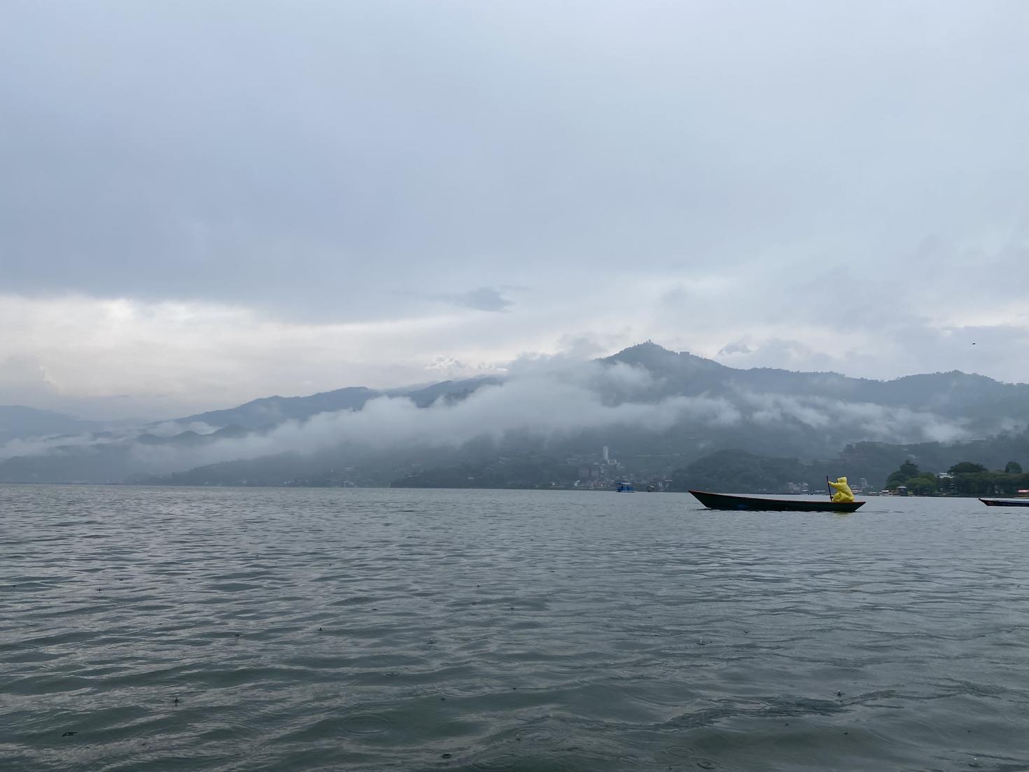 Un paysage marin avec une colline et un temps brumeux.
