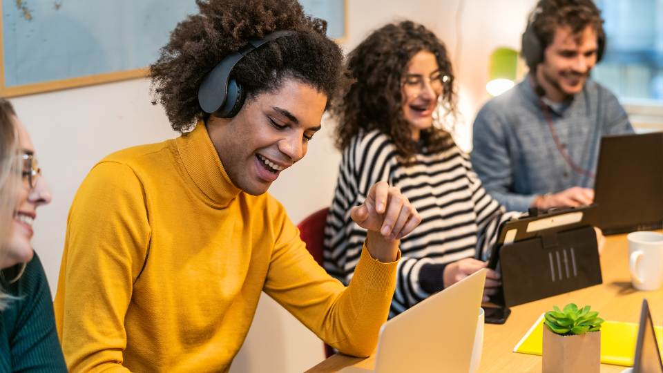 Students smiling in front of their laptops