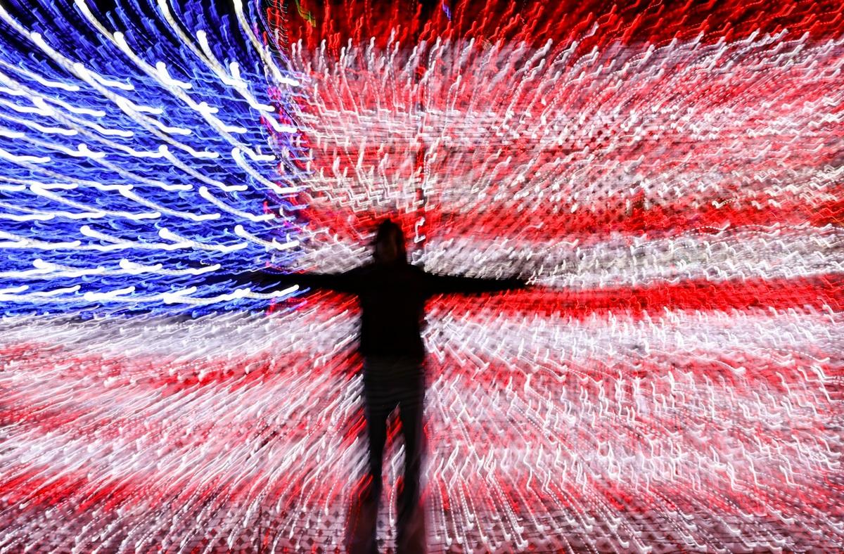 Silhouette against blurry American flag