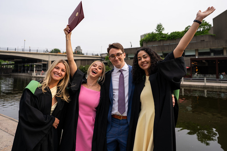 Quatre diplômés en médecine souriant et levant les bras