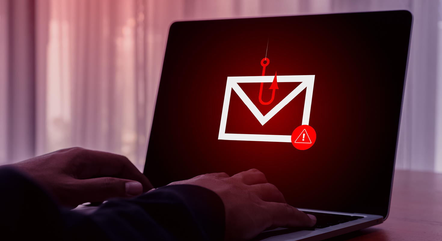 L'écran d'un ordinateur portable montrant un hameçon rouge attrapant une enveloppe sert d'avertissement pour mettre en garde contre les tentatives d'hameçonnage.