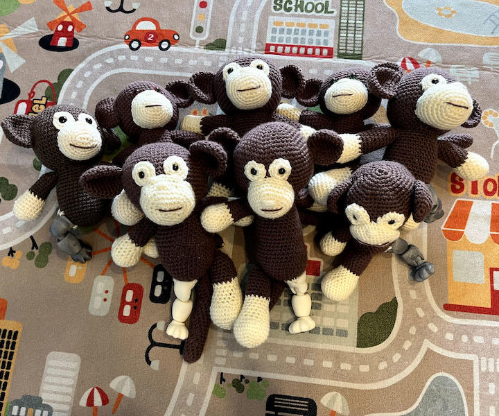 eight crocheted monkeys in a group