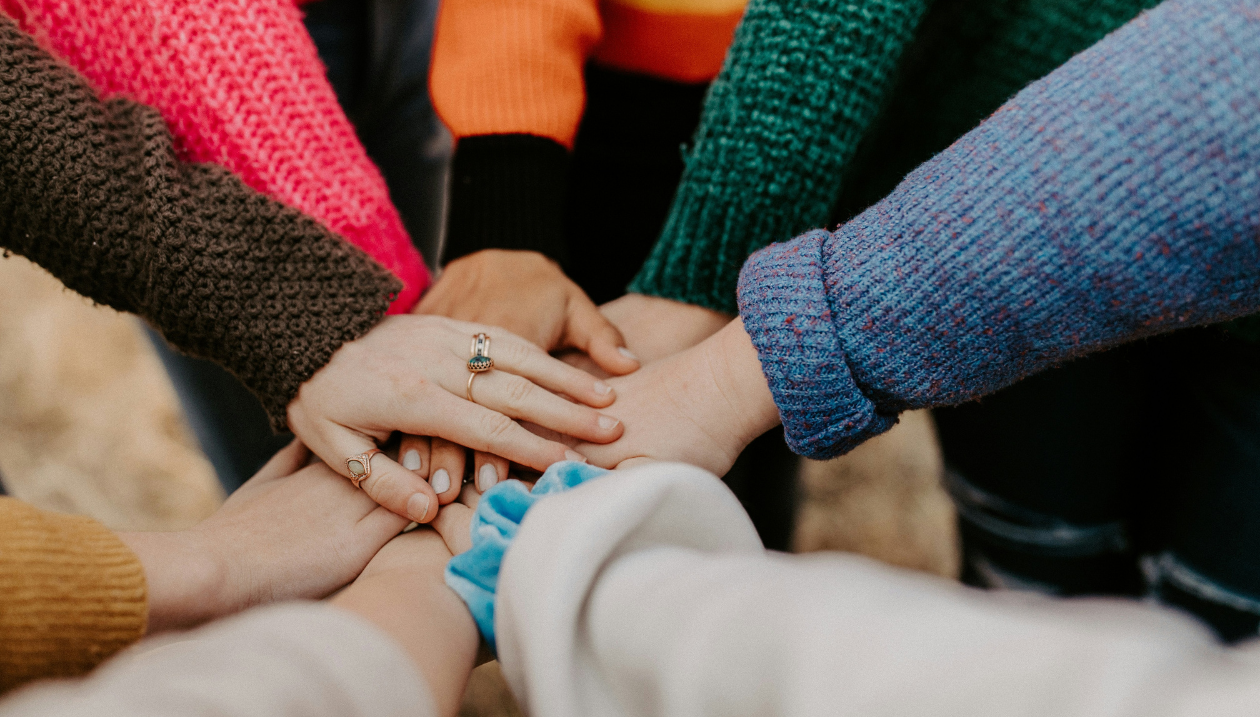 Mains jointes de plusieurs personnes en signe d’unité, de solidarité et de travail d’équipe.