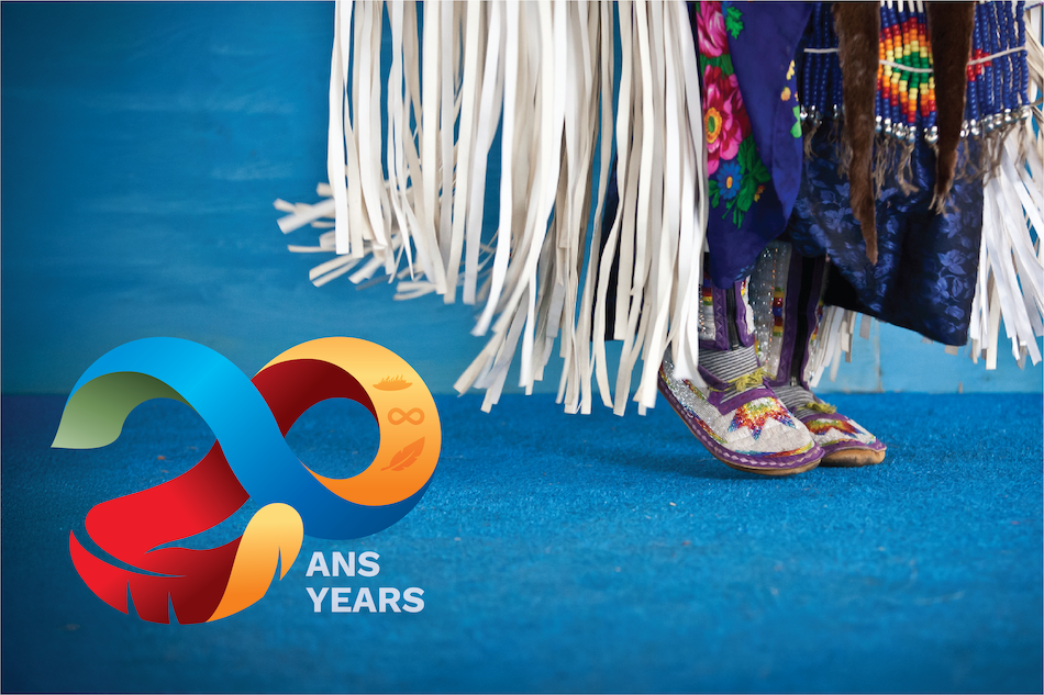 Les pieds d’une danseuse autochtone sur un plancher bleu, avec le logo du 20e anniversaire du Programme autochtone en médecine superposé